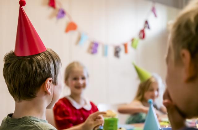 Kinder feiern einen Geburtstag im Naturkundemuseum und sitzen am Tisch.