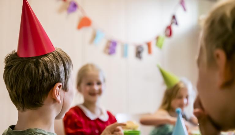 Kinder feiern einen Geburtstag im Naturkundemuseum und sitzen am Tisch.
